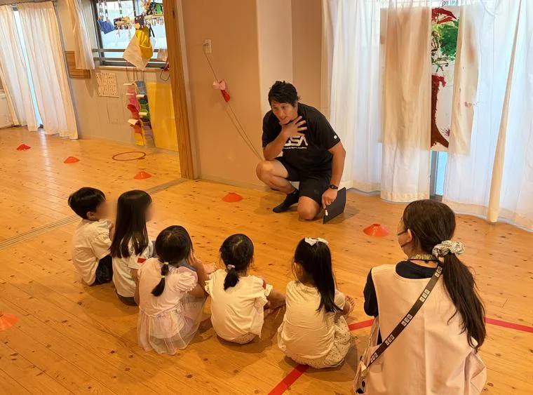 園児がコーチの話を聞いている様子